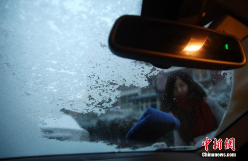 11月21日，露天停放的機動車被冰雪覆蓋，車主出行前除冰。當日，北京降下今冬初雪，前半夜的冰雨將氣溫拉至冰點以下，而后雨轉為雪。<a target='_blank'  _fcksavedurl='http://www.chinanews.com/'></table>中新社</a>記者 楊可佳 攝