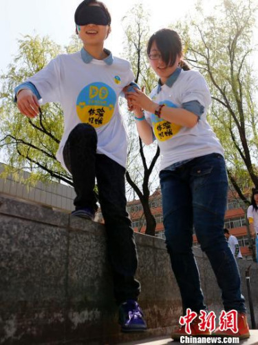 資料圖：2014年3月29日，百余名大學(xué)生志愿者進(jìn)行“黑暗體驗(yàn)”。<a target='_blank'  _fcksavedurl='http://www.chinanews.com/'></table>中新社</a>發(fā) 富田 攝